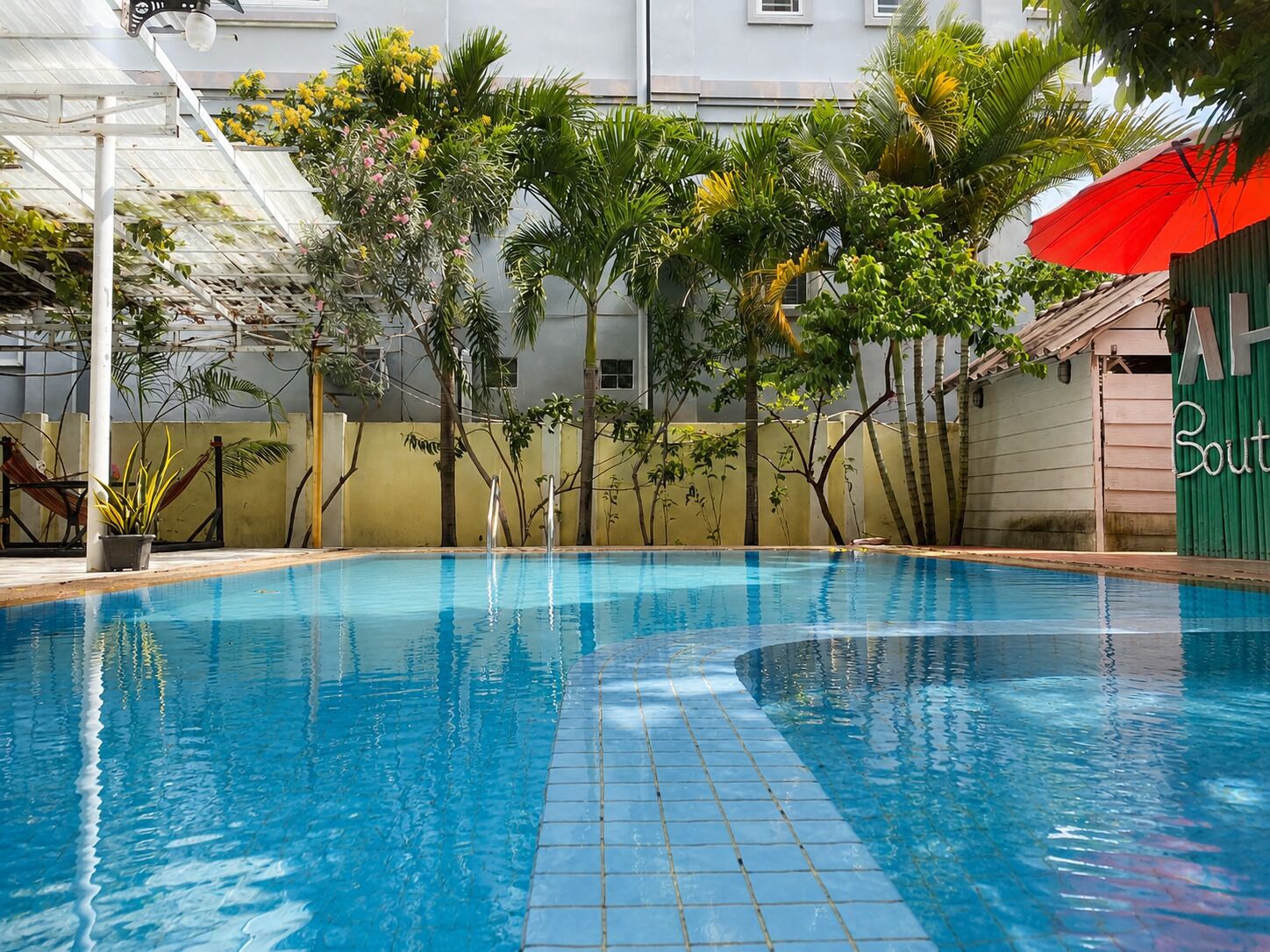 Una piscina al aire libre, sombrillas, sillones reclinables de piscina