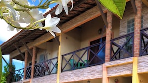 A building with a two-story balcony, a fire extinguisher, and a staircase. - Vila do Pôr do Sol  (Aracati)