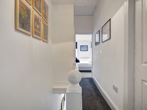 Stylish hallway leads to a cozy bedroom with a comfortable bed.