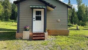 A small, single-story building with a white door and a small porch area.