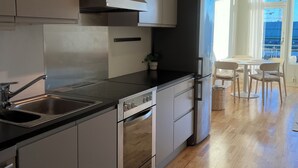 A modern kitchen with stainless steel appliances, a built-in oven, and a black countertop. - Heart of Trondheim (Trøndelag)
