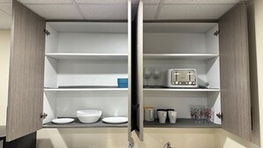 A kitchen with a built-in oven, a sink, and a countertop with a toaster and cups. - Private Cozy 1 Bedroom Basement Suite (Winnipeg)