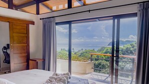 A bedroom with a large bed, a view of the ocean, and a balcony with a railing. - Luxury Home With Ocean View (Provincia de Guanacaste)