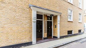 A brick building with a white entrance and a sign that reads "Marylebone Apartments."