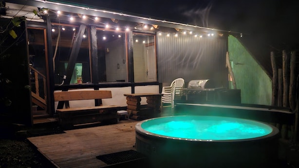 An outdoor hot tub area with a wooden deck, benches, and a grill. - Alte Schreinerei, Modernisiert Fachwerkhaus mit Fernblick auf die Berge 12-16 P (Diemelsee)