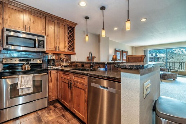 A modern kitchen with stainless steel appliances, wooden cabinets, and a large island. - Spacious Seasons Vacation Home Steps To Lift (Avon)