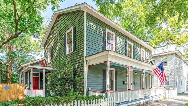 A two-story house with a porch, a red door, and an American flag. - Gorgeous Apt in Heart of Downtown: The Hall House (Wilmington)