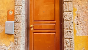 Una puerta de madera con un arco de piedra, un buzón y un número de casa.