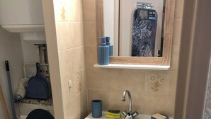 Une salle de bain avec des toilettes, un lavabo et un miroir.