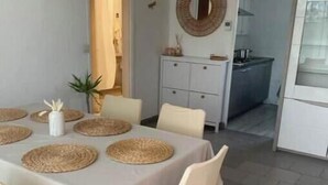 A dining area with a table set for four, clear chairs, a white tablecloth, and woven placemats. - T3 Marseille 10mn drive from Velodrome & beach (Marseille)
