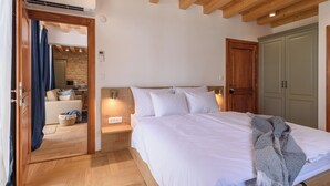 A bedroom with a large bed, wooden headboard, and a cozy atmosphere. - Oleander Center Suites (Trogir)