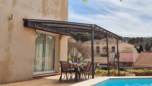 Un bâtiment doté d’une piscine, d’un espace extérieur aménagé et d’une pergola.