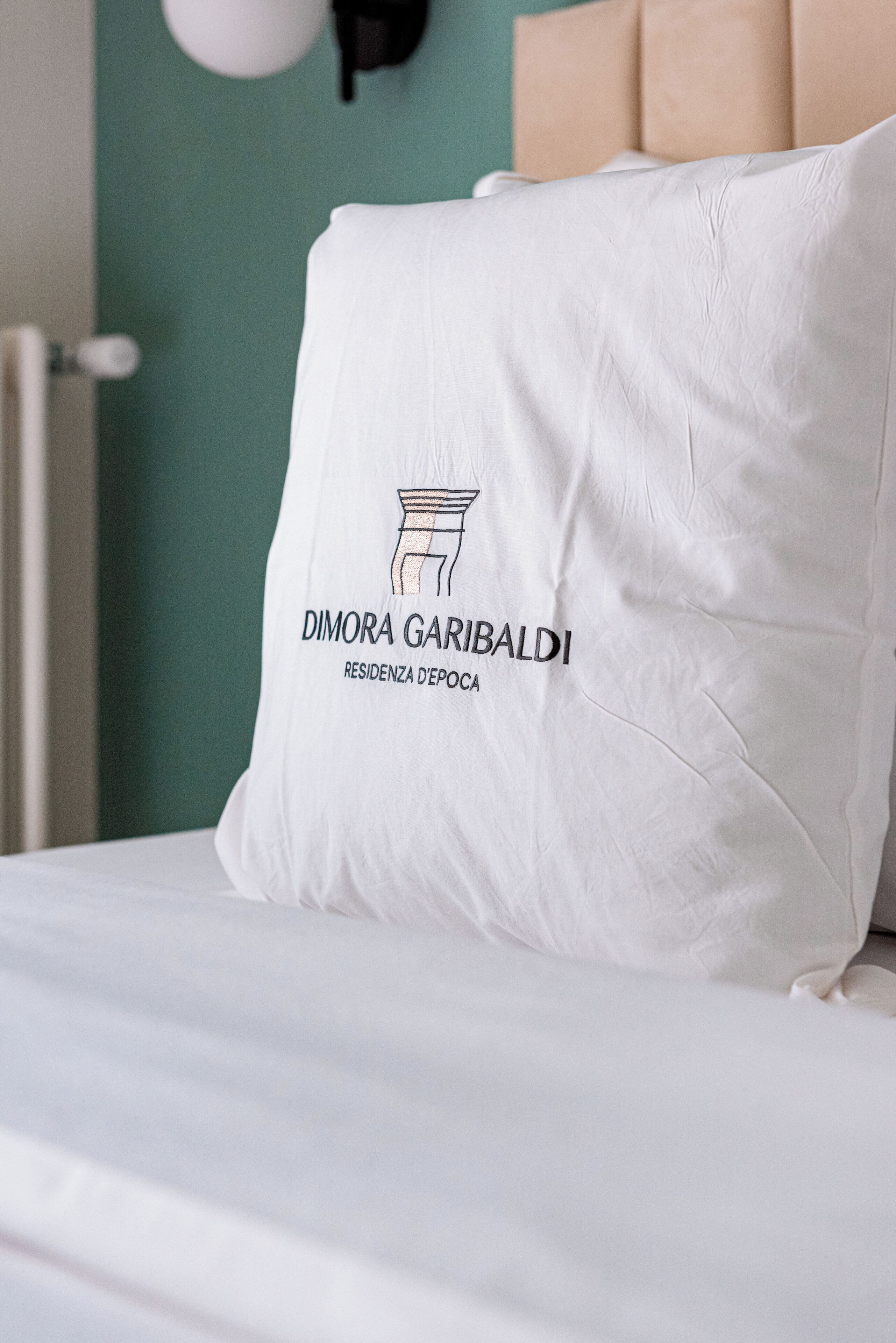 Un almohadilla blanca con un logotipo y texto sobre una cama.