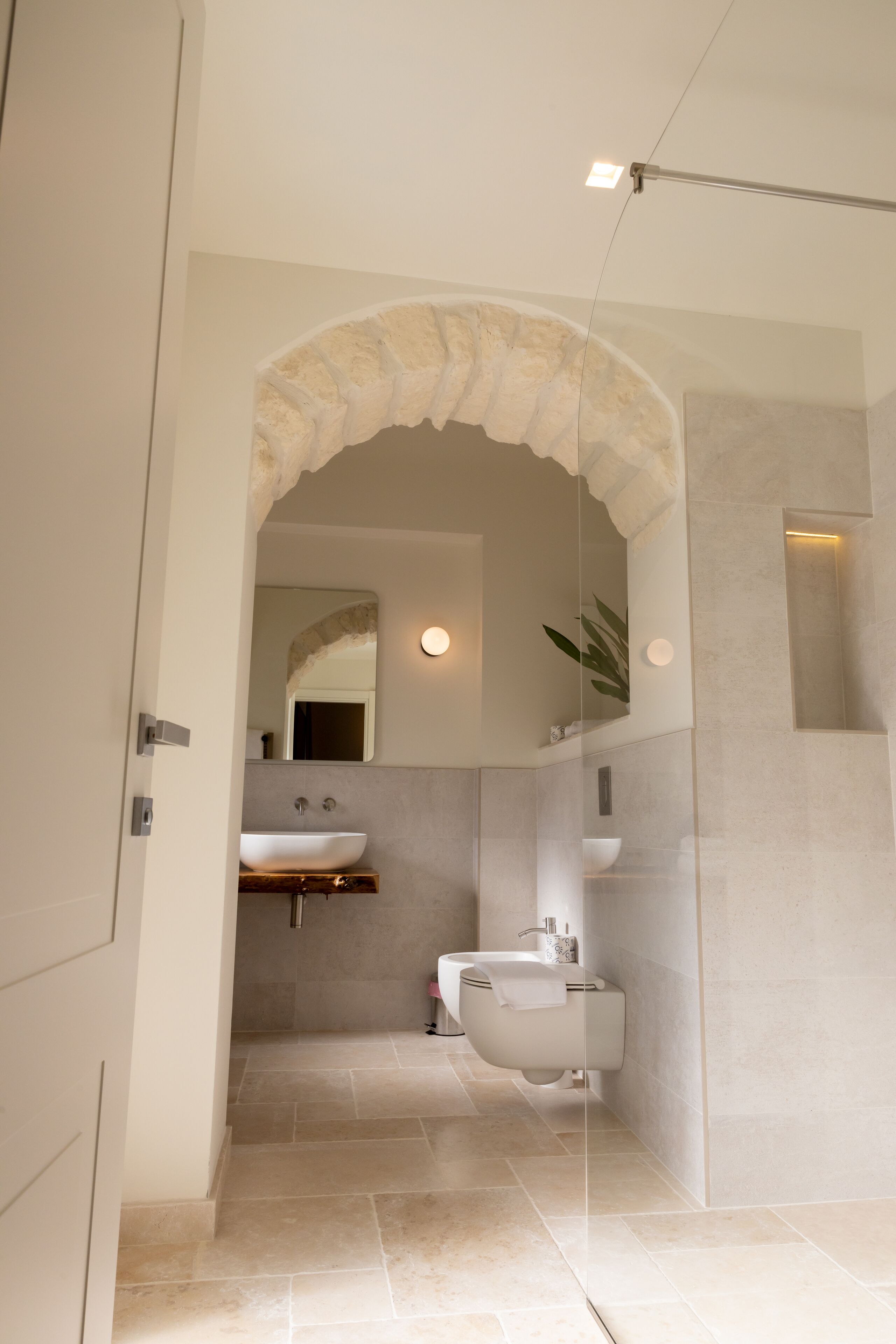 A modern bathroom with a freestanding bathtub, a sink, and a mirror.
