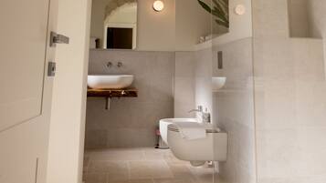 A modern bathroom with a freestanding bathtub, a sink, and a mirror.