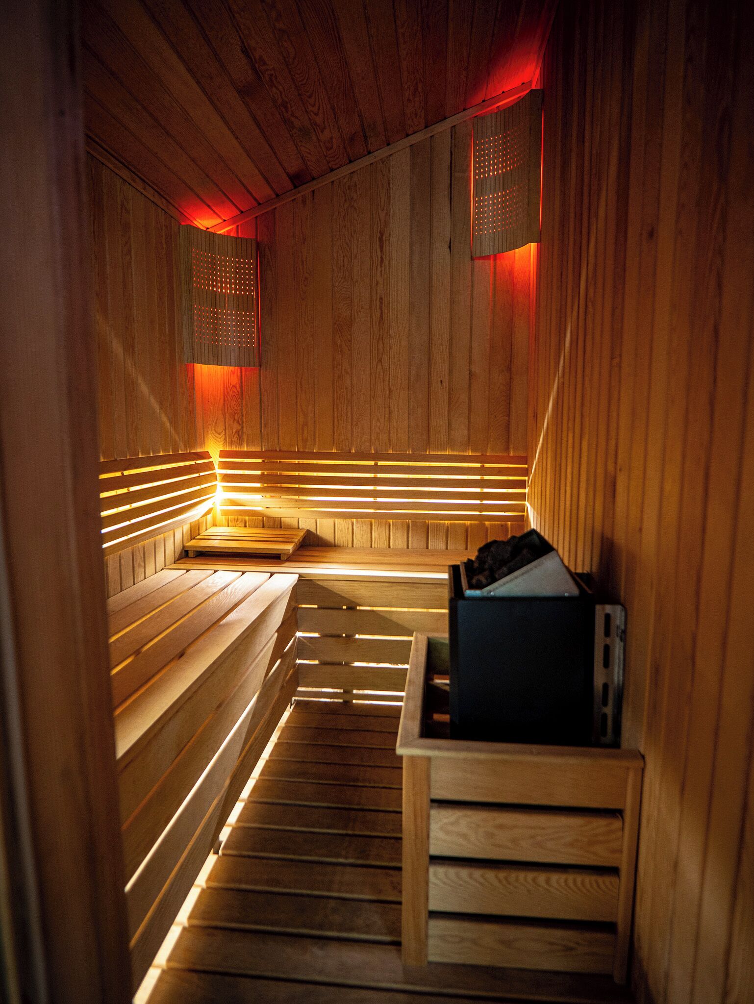 Eine Sauna mit Holzbänken und einem Ofen.