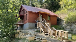 A wooden cabin with a metal roof, a wooden staircase, and a stone foundation. - Luxury cabin with a "mountain  view" a hot tub, pet friendly and internet (Slade)