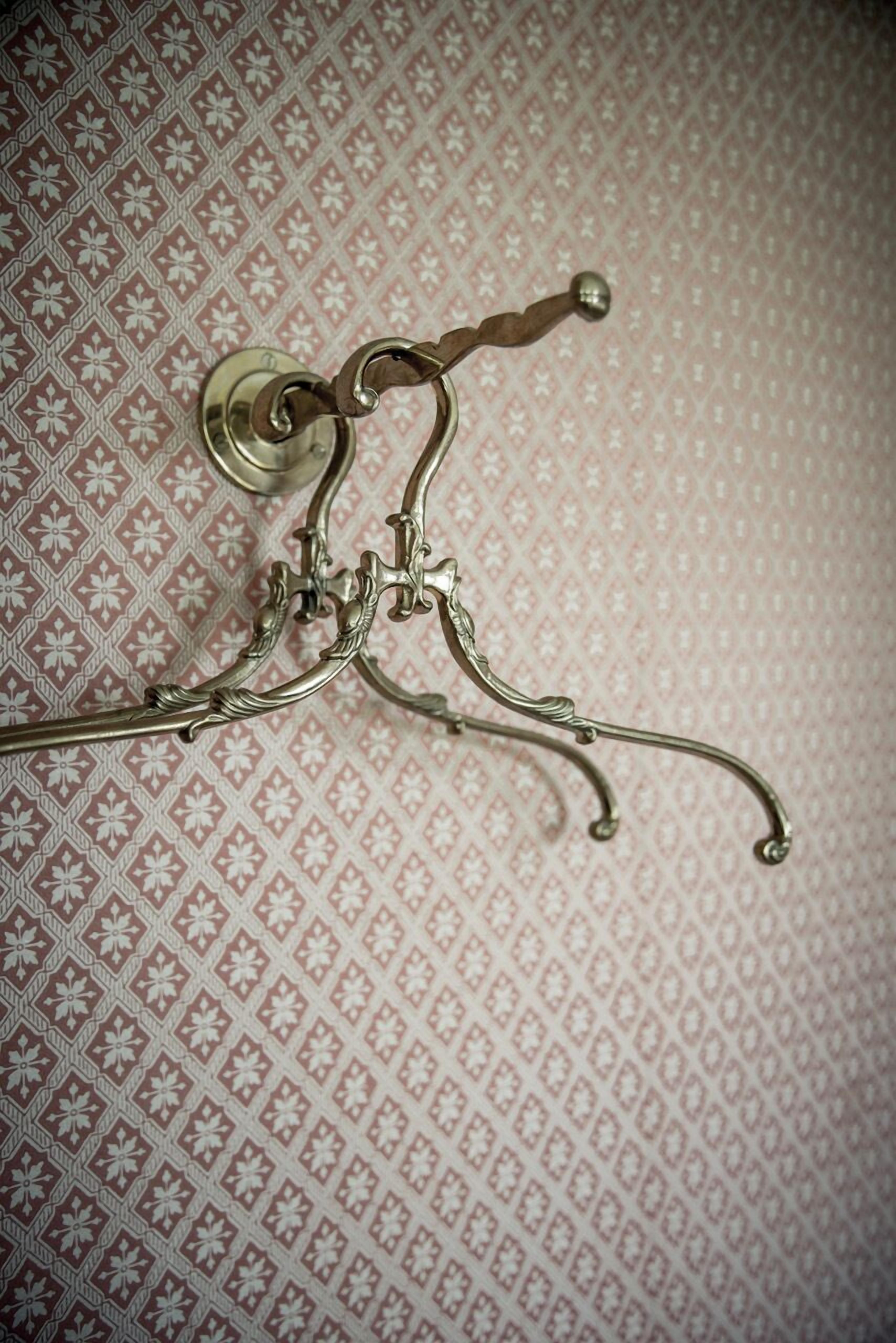 Ein Metallbettgestell mit geschwungenem Design und einem runden Knopf am Kopfteil.