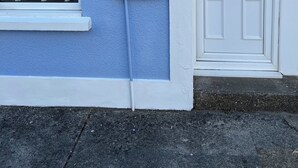A blue house with a white door and a window. There is a sign that says "Castle Cottage" and the number "11" on the wall. - Castle cottage in the  town of Tenby 1 min walk  to the town 5 min walk to beach (Tenby)