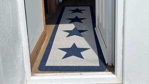 A hallway with a star-patterned rug leading to a door. - Castle cottage in the  town of Tenby 1 min walk  to the town 5 min walk to beach (Tenby)