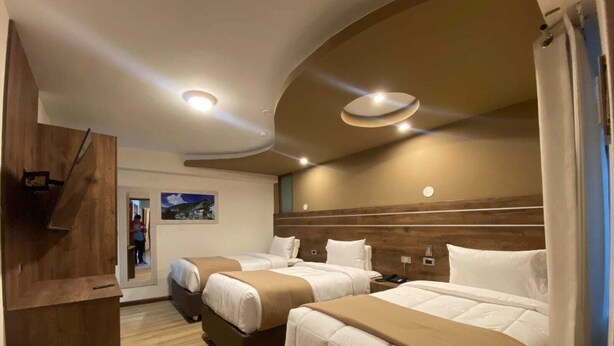 A hotel room with two beds, a wooden desk, and a painting on the wall. - HOTEL INKA LAM -Cusco (Cusco)