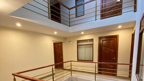 A multi-level interior with a central staircase, wooden doors, and a glass railing. - HOTEL INKA LAM -Cusco (Cusco)