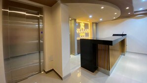 A modern hotel reception area with a sleek reception desk, a glass elevator, and a well-lit interior. - HOTEL INKA LAM -Cusco (Cusco)