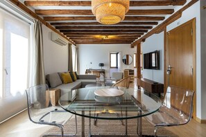 A modern living room with a glass dining table, a sofa, and a TV. - Apartamento Luminos y Tranquilo Alado de la Plaza Mayor (Madrid)