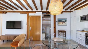 A modern kitchen with a glass dining table, wooden chairs, and a hanging light fixture. - Apartamento Luminos y Tranquilo Alado de la Plaza Mayor (Madrid)