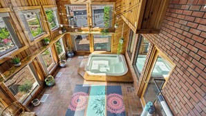 Un'area benessere con vasca idromassaggio, pareti in legno e ampie finestre.
