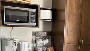 Une petite cuisine équipée d’un four à micro-ondes, d’une machine à café et d’un réfrigérateur.