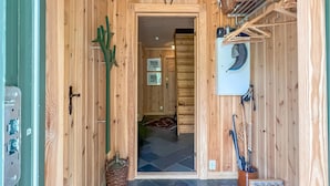 A wooden interior with a door leading to a room, a wall-mounted coat rack, and a basket on the floor. - 3 bedroom stunning home in Vossestrand (Vossestrand)