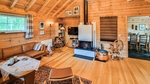A cozy cabin interior with a wooden interior, a fireplace, a sofa, a dining area, and a television. - 3 bedroom stunning home in Vossestrand (Vossestrand)