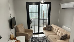 Ein Wohnzimmer mit Sofa, Sessel und Esstisch mit Dekoration.