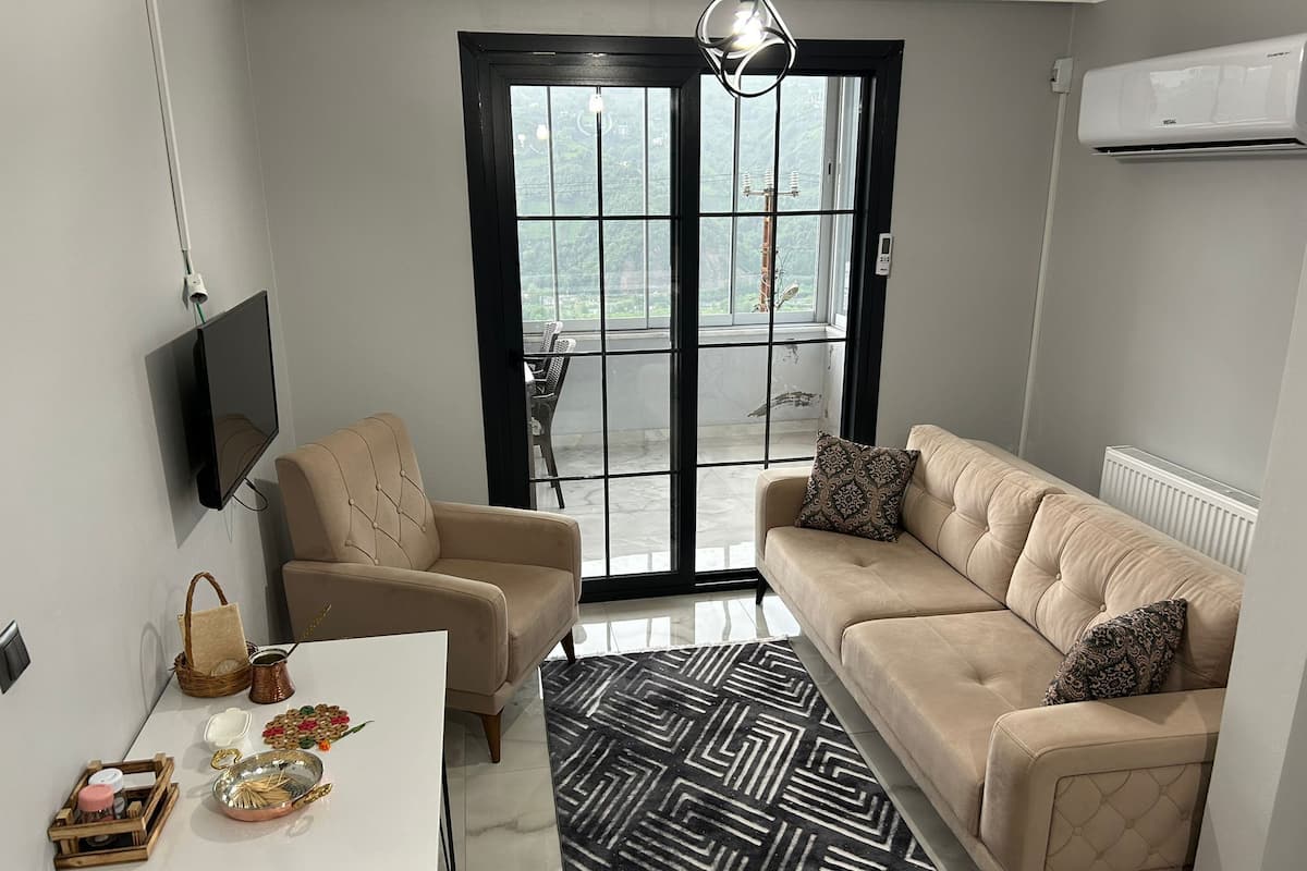 Un salon comprenant un canapé, un fauteuil et une table à manger agrémentée d’objets décoratifs.