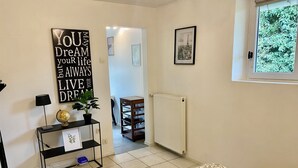 A room with a bed, a radiator, a framed picture, a shelf with a globe and a plant, and a motivational quote on the wall. - Charmant Studio à Coutevroult (Coutevroult)