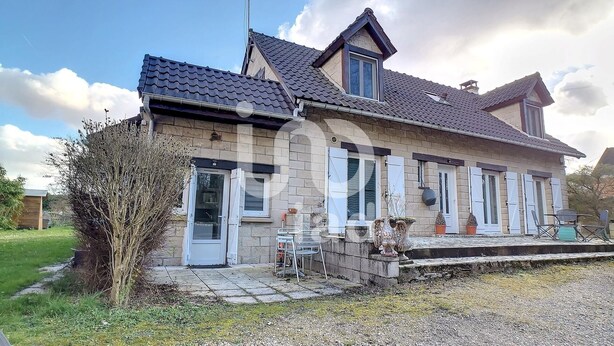 A two-story house with a stone facade, a tiled roof, and a small porch with outdoor seating. - Charmant Studio à Coutevroult (Coutevroult)