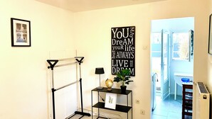 A room with a black metal rack, a globe, a potted plant, and a motivational quote on the wall. - Charmant Studio à Coutevroult (Coutevroult)