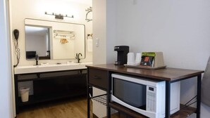A compact kitchenette with a microwave, coffee maker, and a small table. - The Golden Spurs (Panguitch)
