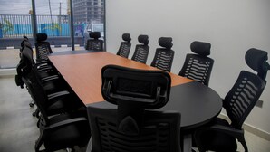 A conference room with a long table and black chairs with headrests. - Hotelinn Oniru  (Lagos)
