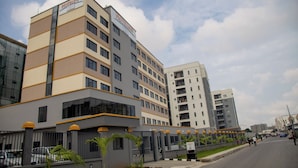 A multi-story hotel with a modern design, featuring a prominent sign at the top. - Hotelinn Oniru  (Lagos)