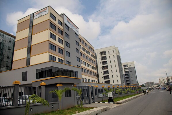A multi-story hotel with a modern design, featuring a prominent sign at the top.