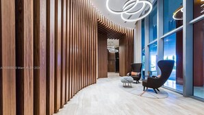 Een modern interieur met een wand van houten panelen, een lichtgekleurde vloer en eigentijds meubilair.