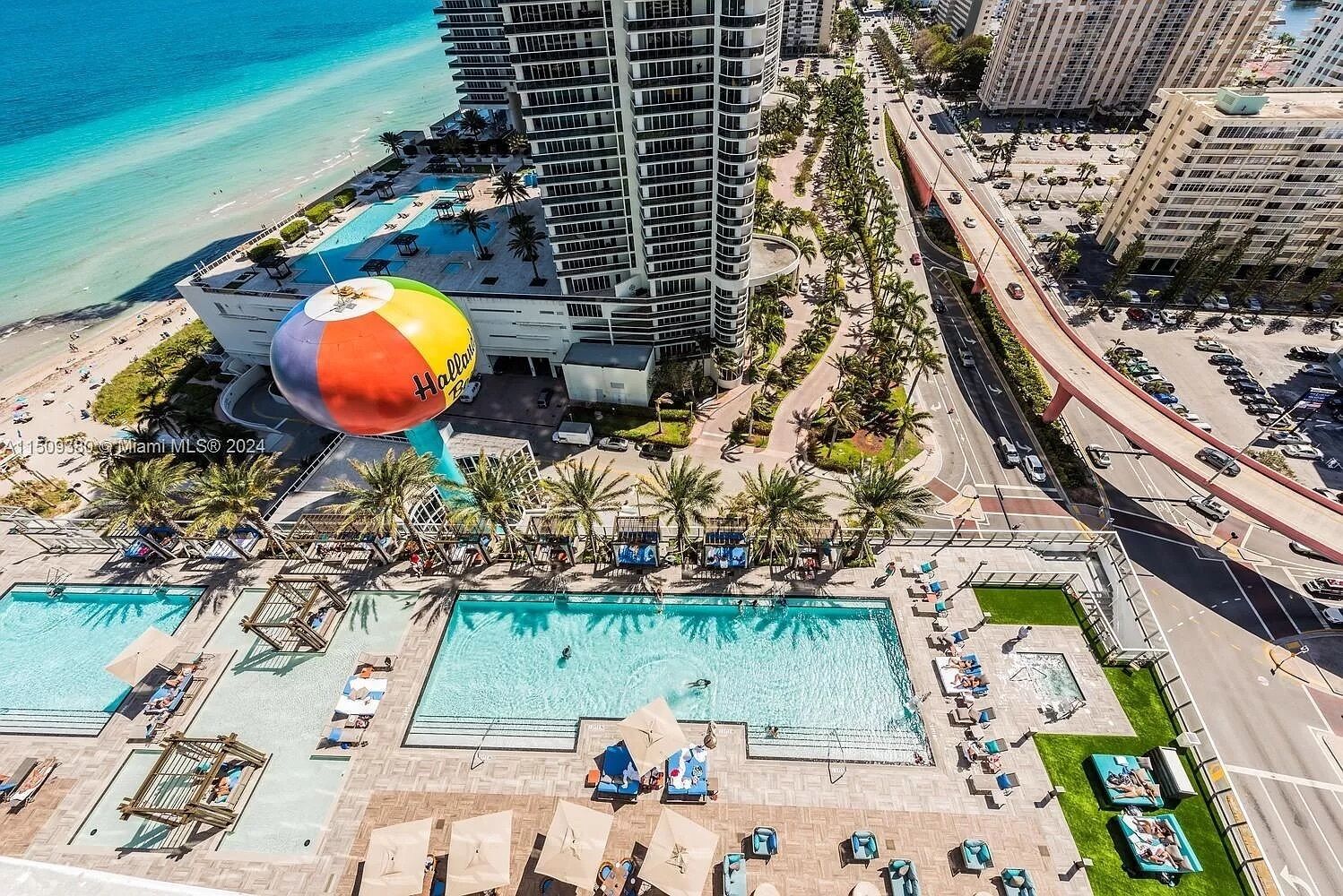 A high-rise hotel with a rooftop pool and a large water slide.