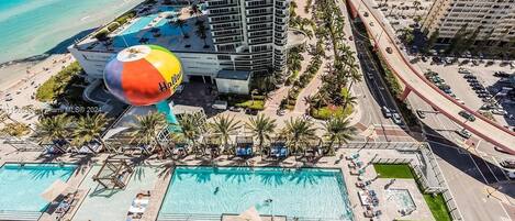 A high-rise hotel with a rooftop pool and a large water slide.