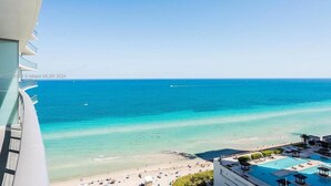 Hotel aan het strand met zwembad, strand en uitzicht op de oceaan.