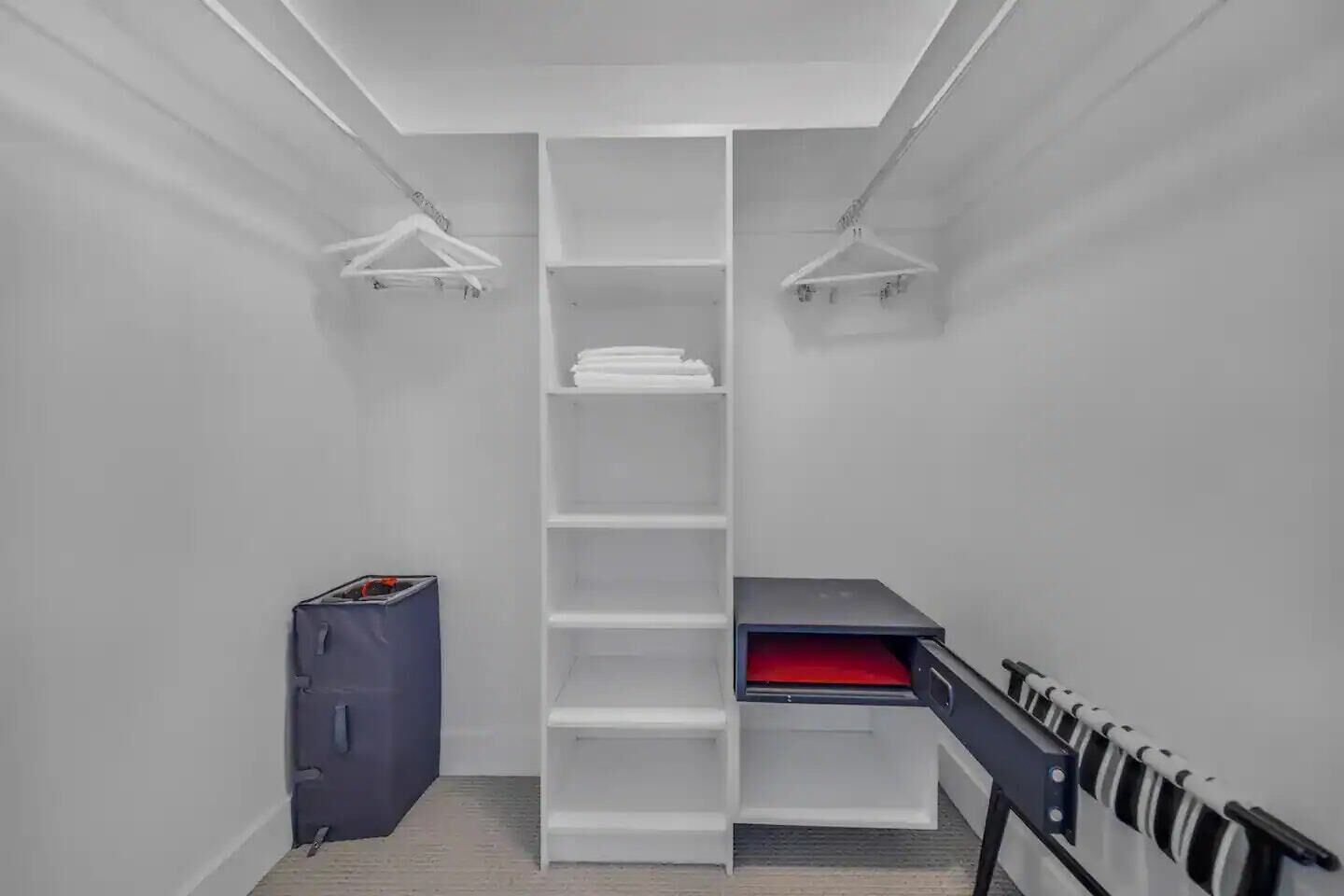 Un armario de parqué con estanterías blancas, un mueble de almacenamiento azul y un cajón rojo.