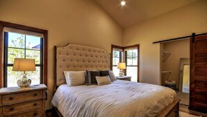 Ein Schlafzimmer mit einem großen Bett, Nachttischen aus Holz und einem Holzschrank.