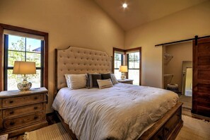 A bedroom with a large bed, wooden nightstands, and a wooden wardrobe. - Montana Mountain Escape (Red Lodge)