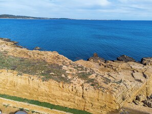 A coastal landscape with rocky terrain and a view of the sea. - Le Castella House (Isola di Capo Rizzuto)